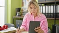 Young blonde woman business worker using touchpad taking notes at office Royalty Free Stock Photo