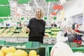 Young blonde woman buys fruit in the supermarket. Healthy food and vitamins Royalty Free Stock Photo