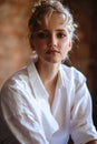 Young blonde woman in a casual white shirt and jeans in a loft interior, close up fashion portrait