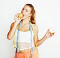 Young blonde woman choosing between donut and apple fruit isolated on white background, lifestyle people concept Royalty Free Stock Photo