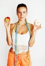 Young blonde woman choosing between donut and apple fruit isolated on white background, lifestyle people concept Royalty Free Stock Photo