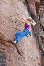 Young blonde woman climbing an extreme diffcult rock Royalty Free Stock Photo