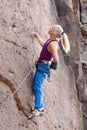 Young blonde woman climbing an extreme diffcult rock Royalty Free Stock Photo