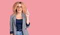 Young blonde woman with curly hair wearing business jacket and glasses pointing finger up with successful idea Royalty Free Stock Photo