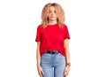 Young blonde woman with curly hair wearing casual red tshirt looking sleepy and tired, exhausted for fatigue and hangover, lazy Royalty Free Stock Photo