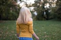Young blonde woman dancing in the park, turning around Royalty Free Stock Photo