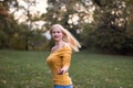 Young blonde woman dancing, turning around in the park Royalty Free Stock Photo