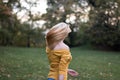 Young blonde woman dancing, turning around in the park Royalty Free Stock Photo