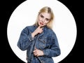 Young blonde woman in denim jaket and jeans shows Index finger to the lips on white background Royalty Free Stock Photo