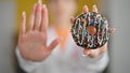 Young blonde woman dietician holding doughnut doing stop gesture with hand at clinic