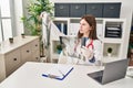 Young blonde woman doctor looking xray sitting on table at clinic Royalty Free Stock Photo