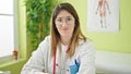 Young blonde woman doctor smiling confident wearing glasses at clinic Royalty Free Stock Photo