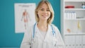 Young blonde woman doctor smiling confident wearing stethoscope at clinic Royalty Free Stock Photo