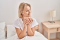 Young blonde woman drinking cup of coffee sitting on bed at bedroom Royalty Free Stock Photo