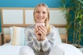 Young blonde woman drinking cup of coffee sitting on bed at bedroom Royalty Free Stock Photo