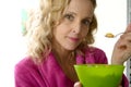 Young blonde woman eating cereals in the morning Royalty Free Stock Photo