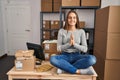 Young blonde woman ecommerce business worker doing yoga sitting on table at office Royalty Free Stock Photo