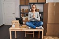 Young blonde woman ecommerce business worker doing yoga sitting on table at office Royalty Free Stock Photo