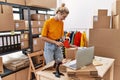 Young blonde woman ecommerce business worker packing cardboard box at office Royalty Free Stock Photo