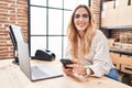 Young blonde woman ecommerce business worker using laptop and smartphone at office Royalty Free Stock Photo