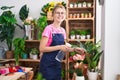 Young blonde woman florist using diffuser working smiling at flower shop Royalty Free Stock Photo