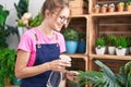 Young blonde woman florist using diffuser working smiling at flower shop Royalty Free Stock Photo