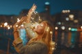 Young blonde woman with garland fairy lights have fun in city at