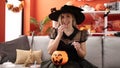 Young blonde woman having halloween party eating candy sweet at home Royalty Free Stock Photo