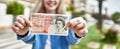 Young blonde woman holding english banknotes pounds, showing money smiling happy and confident outdoors