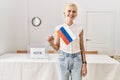 Young blonde woman holding russian flag smiling at electoral college Royalty Free Stock Photo