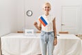 Young blonde woman holding russian flag smiling at electoral college Royalty Free Stock Photo