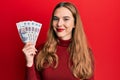 Young blonde woman holding russian 500 ruble banknotes looking positive and happy standing and smiling with a confident smile