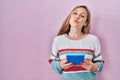 Young blonde woman holding touchpad looking at the camera blowing a kiss being lovely and sexy Royalty Free Stock Photo