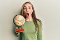 Young blonde woman holding vintage world ball scared and amazed with open mouth for surprise, disbelief face Royalty Free Stock Photo