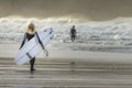 Young blonde woman joins boyfreind surfing, Fistral Beach, Newquay, Cornwall