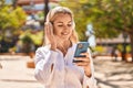 Young blonde woman listening to music at park Royalty Free Stock Photo