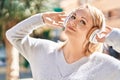 Young blonde woman listening to music at street Royalty Free Stock Photo