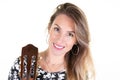 Young blonde woman with long hair posing with wooden acoustic guitar on white wall background Royalty Free Stock Photo
