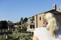 Young blonde woman are looking the panorama to the Imperial forums Fori Imperiali in Rome.