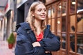 Young blonde woman looking to the side with arms crossed gesture at street Royalty Free Stock Photo