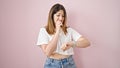 Young blonde woman looking watch with nervous expression over isolated pink background Royalty Free Stock Photo