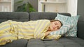 Young blonde woman lying on sofa sleeping at home Royalty Free Stock Photo