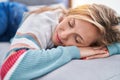 Young blonde woman lying on sofa sleeping at home Royalty Free Stock Photo