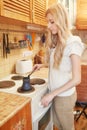 Young blonde woman making coffee Royalty Free Stock Photo