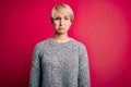 Young blonde woman with modern short hair wearing casual sweater over pink background depressed and worry for distress, crying Royalty Free Stock Photo