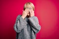 Young blonde woman with modern short hair wearing casual sweater over pink background rubbing eyes for fatigue and headache, Royalty Free Stock Photo