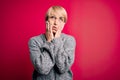 Young blonde woman with modern short hair wearing casual sweater over pink background Tired hands covering face, depression and Royalty Free Stock Photo