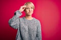 Young blonde woman with modern short hair wearing casual sweater over pink background worried and stressed about a problem with Royalty Free Stock Photo