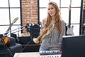 Young blonde woman musician holding trumpet at music studio Royalty Free Stock Photo