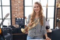 Young blonde woman musician holding trumpet at music studio Royalty Free Stock Photo
